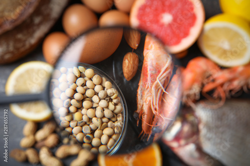 Obraz na płótnie Different products with magnifier focused on soy beans and shrimps, closeup