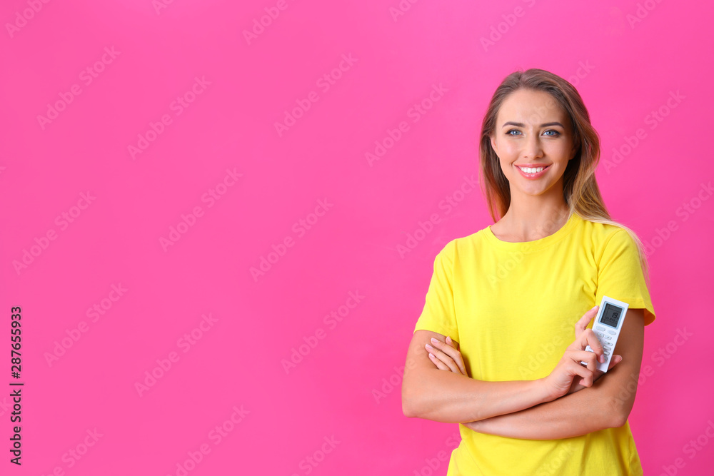 Young woman with air conditioner remote on hot pink background. Space for text Young woman with air conditioner remote on hot pink background. Space for text