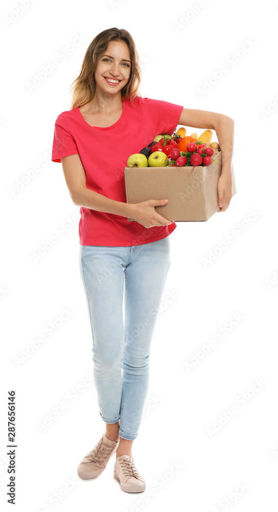 Young woman with box of fresh vegetables on white background