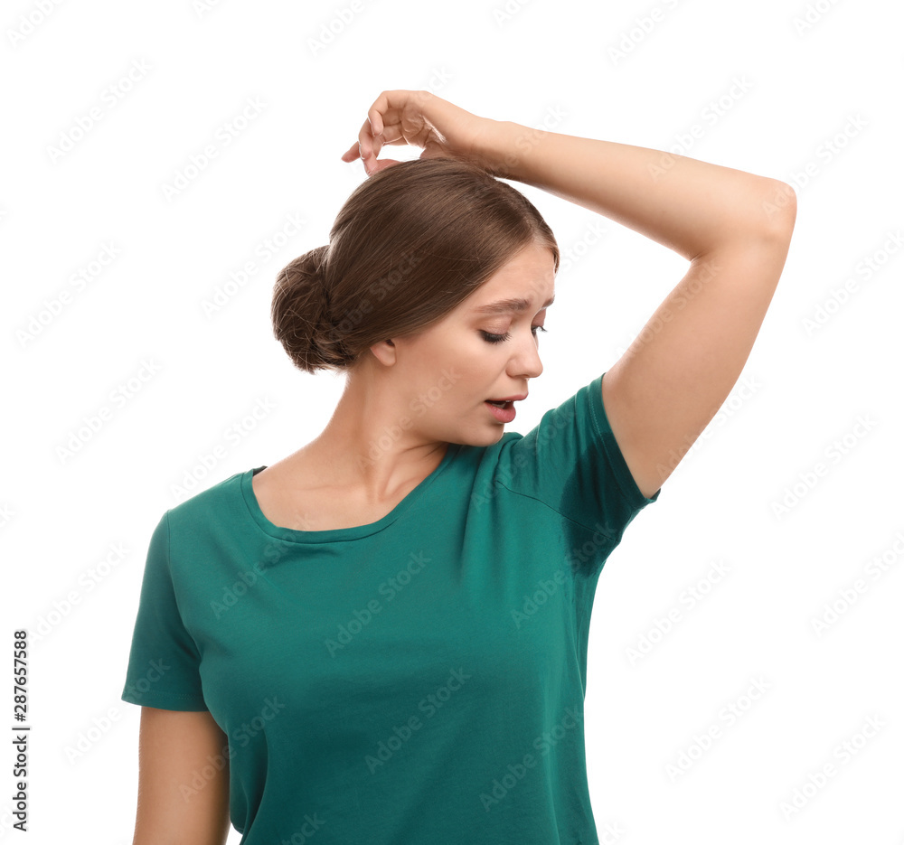 Young woman with sweat stain on her clothes against white background. Using deodorant Young woman with sweat stain on her clothes against white background. Using deodorant