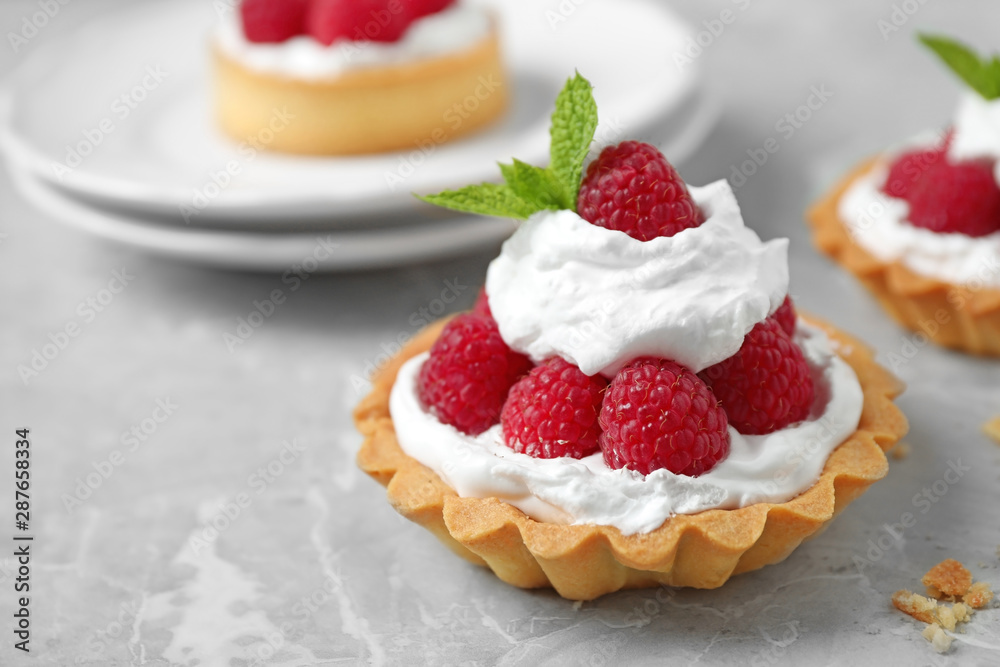 Tarts with raspberries on marble table, closeup. Delicious pastries Tarts with raspberries on marble table, closeup. Delicious pastries