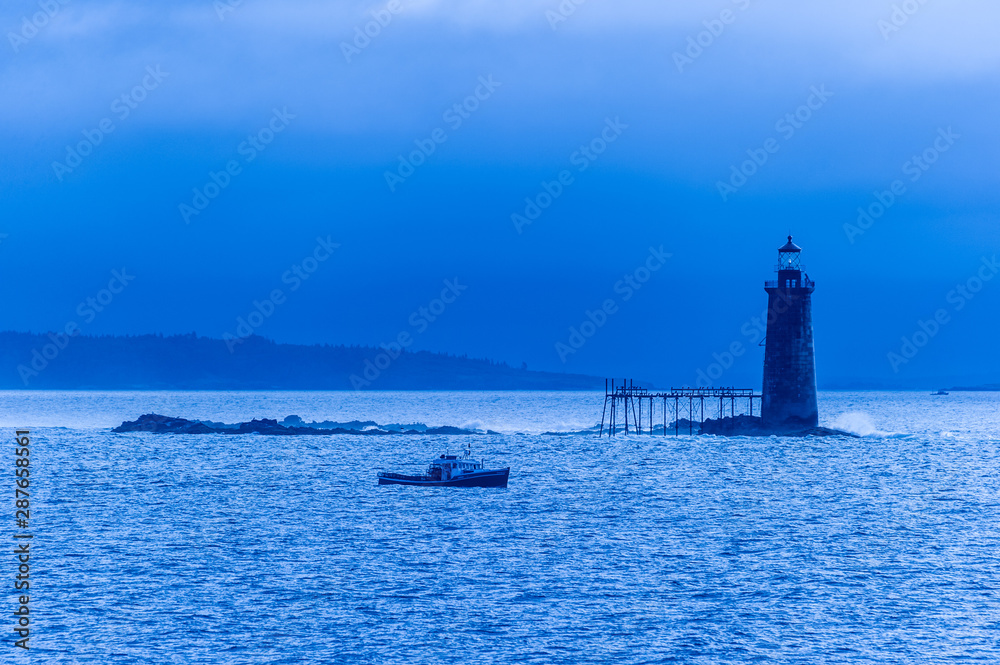 Lobster boat passing the Ram Island Ledge Lighthouse