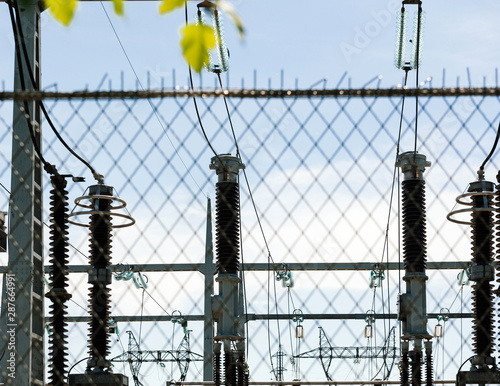 View through security fence of high voltage French power lines hydroelectric power plant at Centrale Hydroelectrique de Gambsheim in the background photo