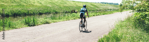 Bild auf Leinwand Rear view of male cyclist riding a sport bike near Rhine River in France