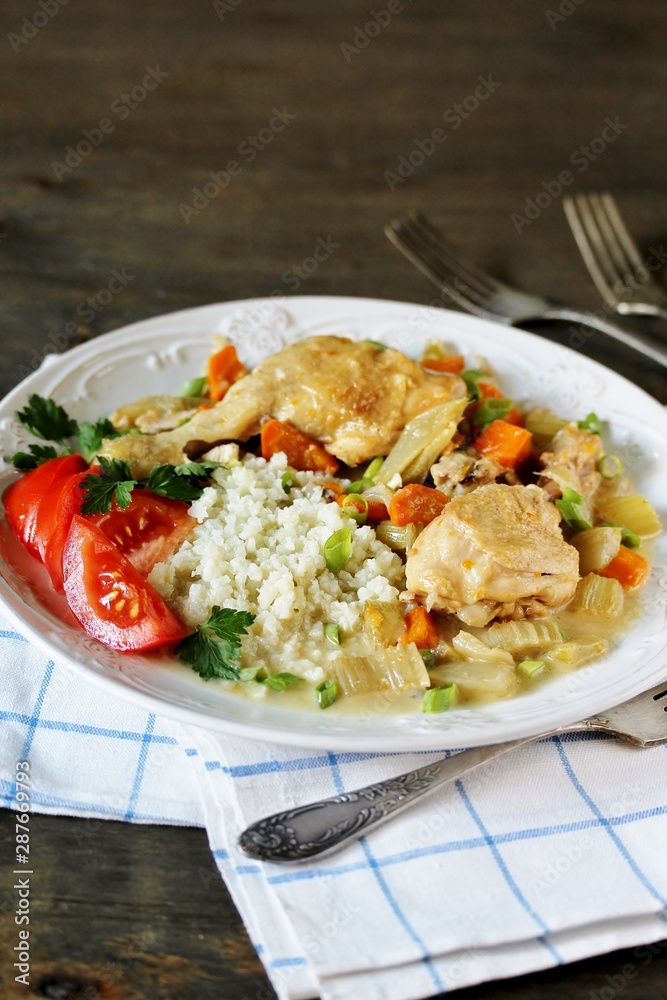 Chicken with Cauliflower Rice. low carbohydrates a lot of protein. stewed chicken with celery and carrots in a white plate. keto dish. 