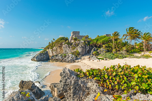 The Caribbean Sea with turquoise waters and white sand beach as a backdrop for the Tulum Maya ruins, Mexico. photo