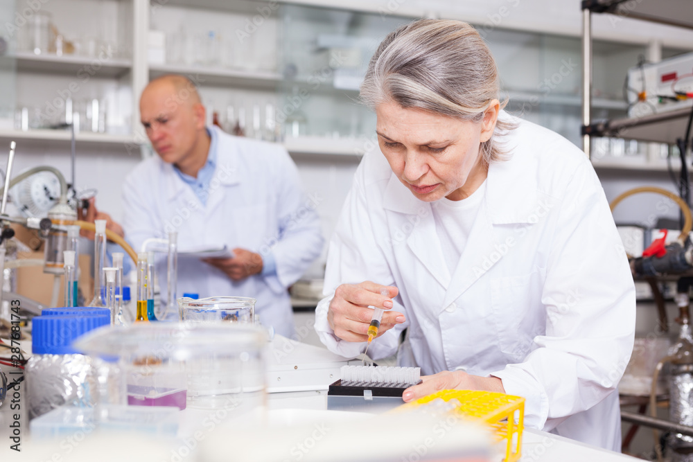 Fototapeta premium Female chemist mixing chemical agents