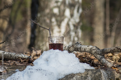 Pouring syrup from birch sap into a glass.