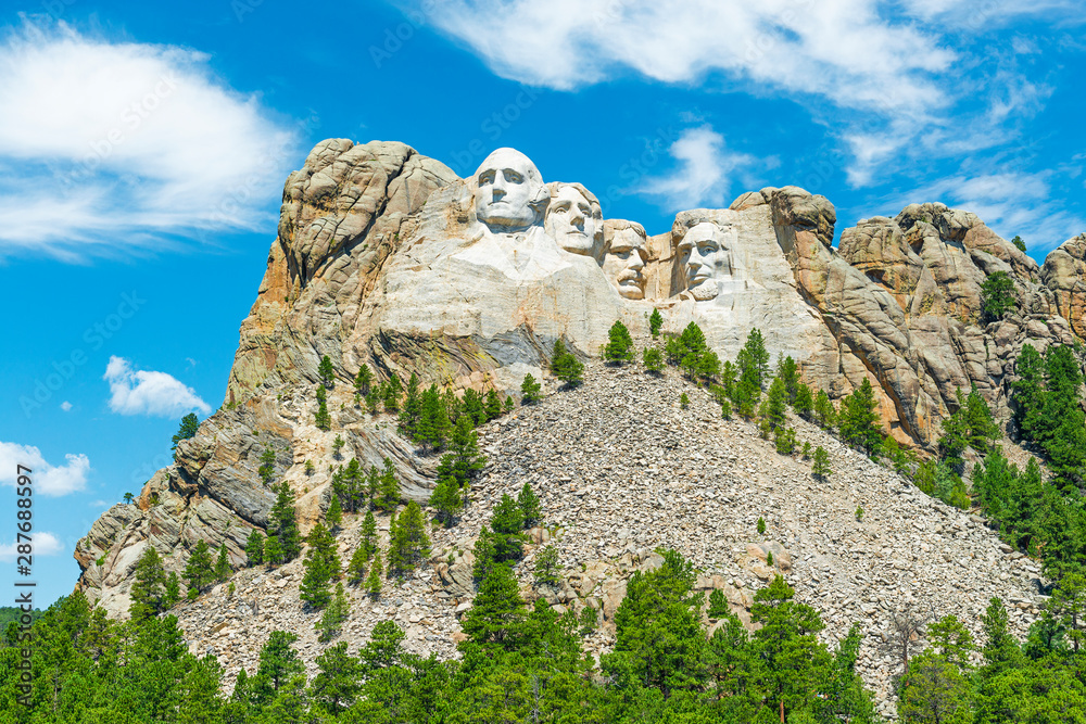 The carved faces of US presidents in Mount Rushmore national monument and the pine tree forest in the Black Hills, Rapid City, South Dakota, United States of America, USA.