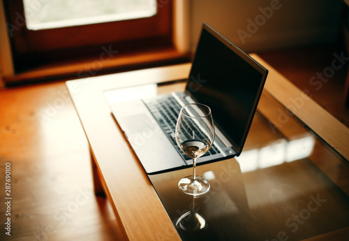 Desk Laptop with wineglass, home office, work in the evenings
