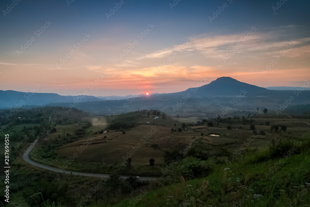 Top view above long road, forest and top hill with red sun light and cloudy sky background, sunrise at Khao Takhian (Takian) Ngo View Point, Khao Kho, Phetchabun, Thailand. Top view above long road, forest and top hill with red sun light and cloudy sky background, sunrise at Khao Takhian (Takian) Ngo View Point, Khao Kho, Phetchabun, Thailand.
