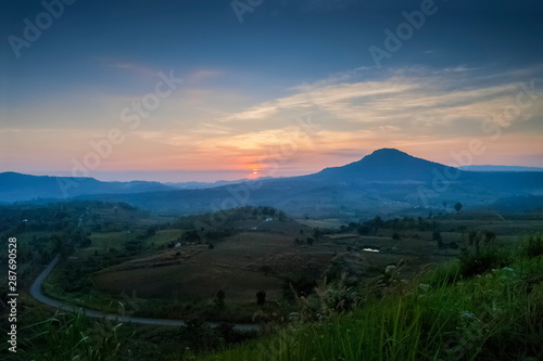 Top view above long road  forest and top hill with red sun light and cloudy sky background  sunrise at Khao Takhian  Takian  Ngo View Point  Khao Kho  Phetchabun  Thailand.