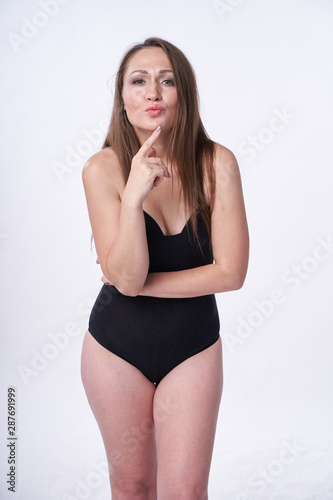 Beautiful girl in swimsuit posing against grey white background. Well-groomed skin. Sexy attire . © nikolay_alekhin