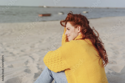 Картината върху платно Smiling young woman enjoying the sun on a beach