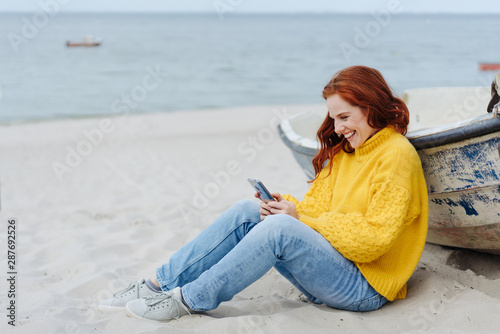 Happy young woman relaxing on a beach in autumn
