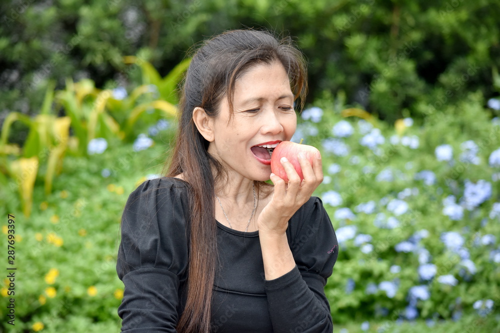 A Happy Female Senior Eating Fruit A Happy Female Senior Eating Fruit