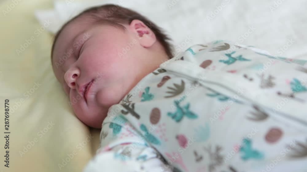 Head of infant with closed eyes, Caucasian baby sleep on bedsheet Head of infant with closed eyes, Caucasian baby sleep on bedsheet