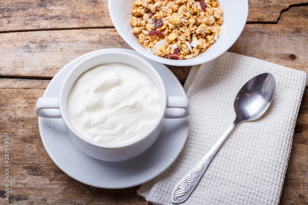 Healthy breakfast background. Muesli with yoghurt in bowl on wooden background Healthy breakfast background. Muesli with yoghurt in bowl on wooden background