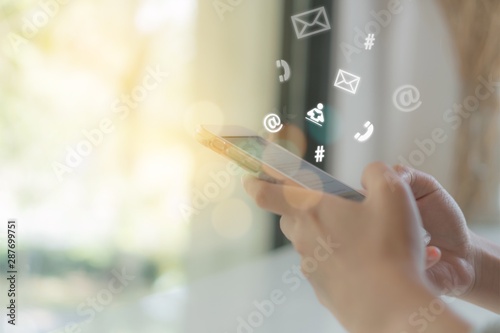 Woman hand using smartphone or tablet to do business, financial or trading stock forex market in park outdoor nature road background.