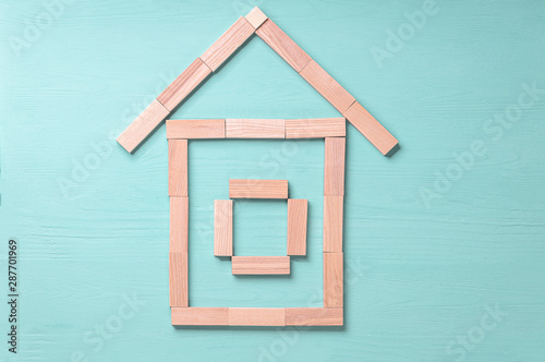 house of wooden blocks, on a blue wooden background, concept