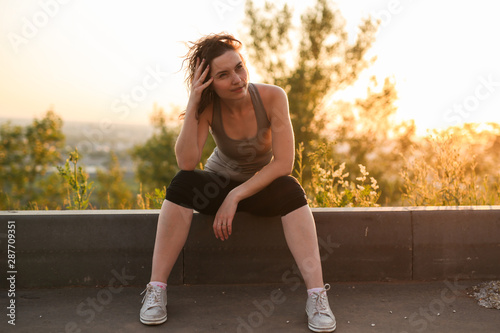 sad depressed woman in shirt sitting in the park