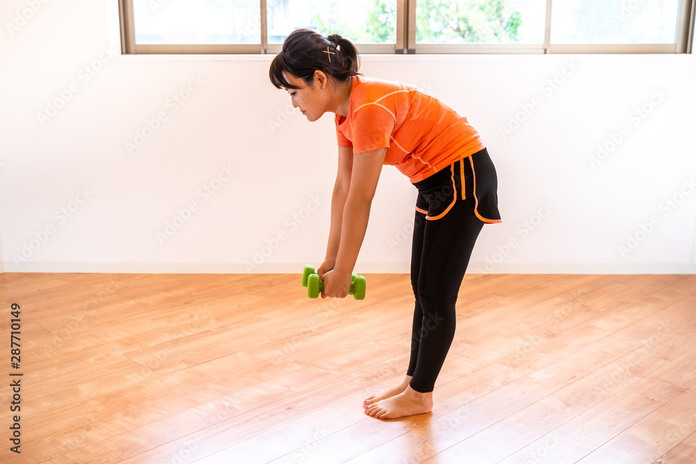 ダンベルで筋トレする女性 ダンベルで筋トレする女性