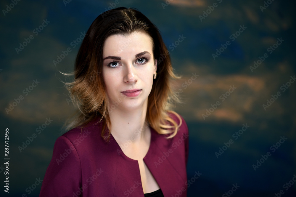Fototapeta premium Close-up portrait of a pretty young business woman on a colorful background.