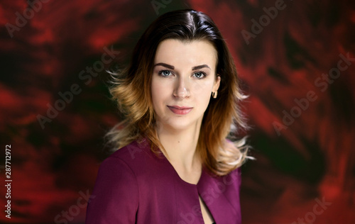 Close-up portrait of a pretty young business woman on a colorful background.