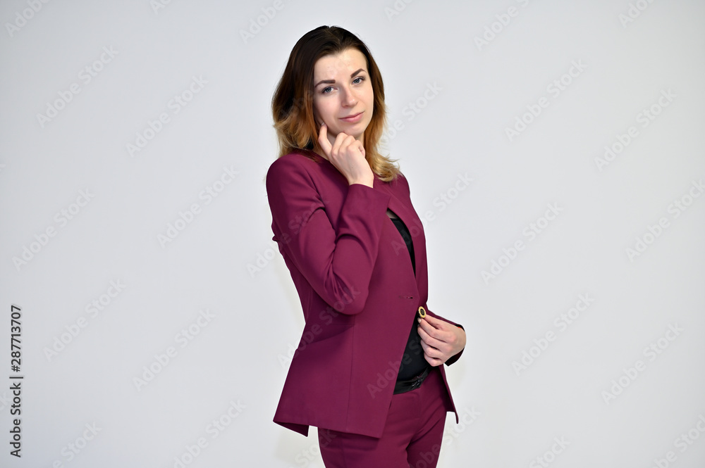 Portrait of a pretty young brown-haired business woman on a white background in a dark business suit. He stands in different poses, talking, different emotions. Portrait of a pretty young brown-haired business woman on a white background in a dark business suit. He stands in different poses, talking, different emotions.