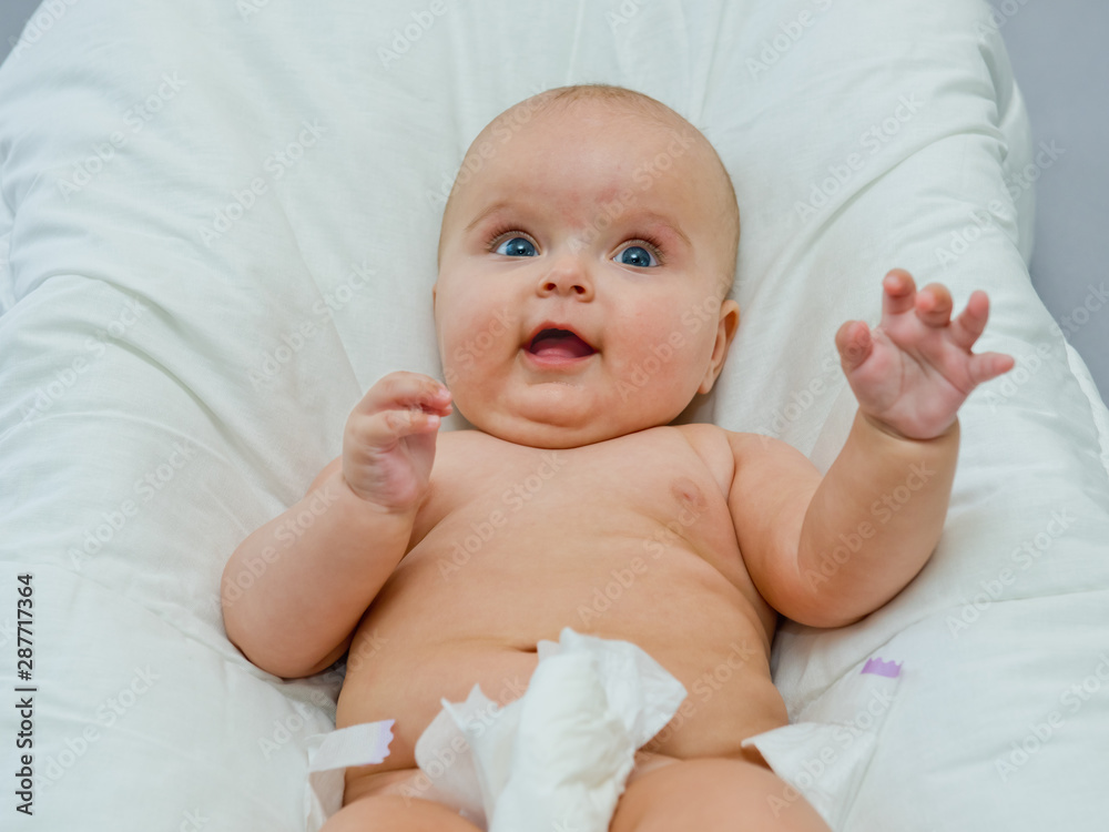 A cute baby takes off his diaper. A cute baby takes off his diaper.