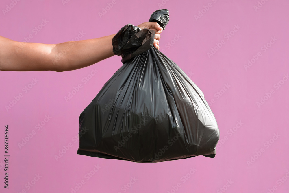 hand holding garbage bag isolate on pink background hand holding garbage bag isolate on pink background