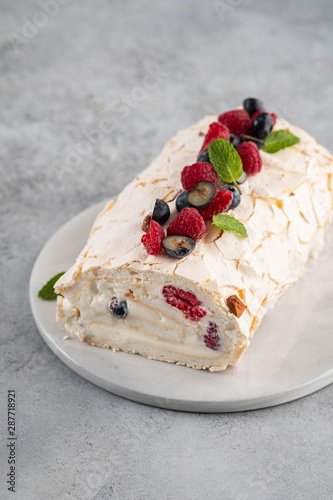 Meringue roll cake with cream and raspberries. Roulade, summer dessert, closeup. photo