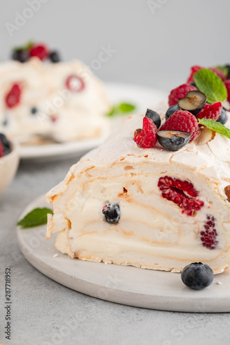 Meringue roll cake with cream and raspberries. Roulade, summer dessert, closeup. photo