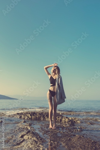 Attractive young model posing on rock 