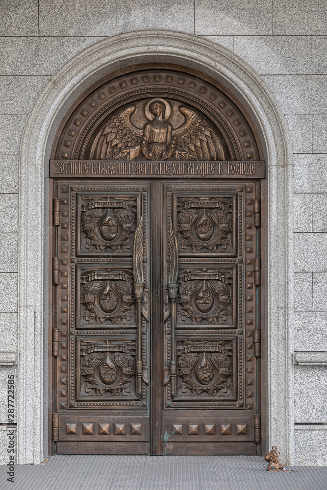 Arched wooden door of church with wood-carving