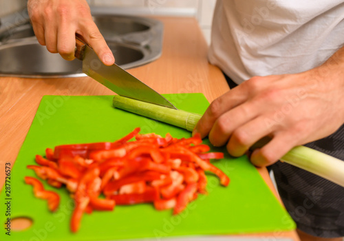Man slicing vegetable red peppers