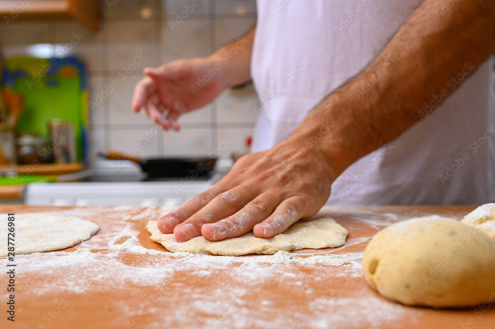 man preparing dough with flour