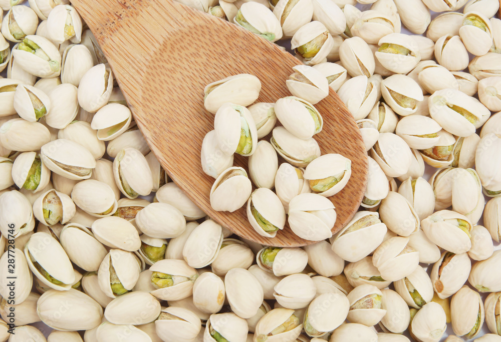 Pistachio nuts and wooden spoon