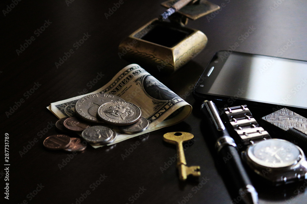 Still life of male cool belongings with dollar bills and coins Still life of male cool belongings with dollar bills and coins