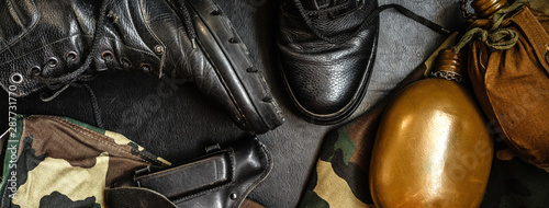 military mobilization war camouflage uniform and boots. A set of military items flask gun on a dark background photo