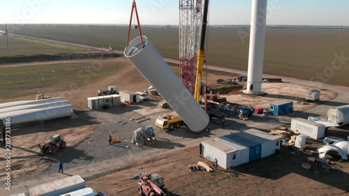 Building process of wind energy power tower mill, under construction. Assembling tower, column, pillar. Green, clean, renewable energy. Aerial footage.
