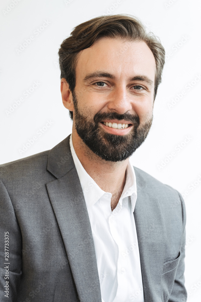 Image closeup of happy satisfied businessman smiling and looking aside while working in office Image closeup of happy satisfied businessman smiling and looking aside while working in office