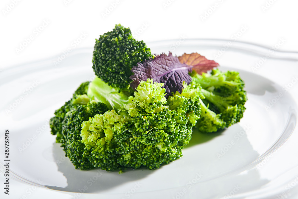 Macro Shot of Steamed Broccoli on White Restaurant Plate Isolated Macro Shot of Steamed Broccoli on White Restaurant Plate Isolated