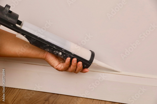 A female contractor using a mastic gun