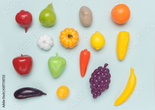 Fototapeta Naklejka Na Ścianę i Meble -   Toy plastic imitations (fake) of different vegetables and fruits on a blue background. Visual material for educating children and expanding their understanding of the world.