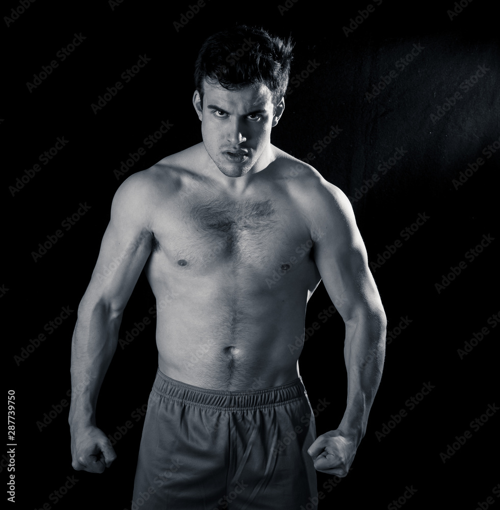 Young fitness muscly man showing his back,shoulders, triceps and biceps muscles after training Young fitness muscly man showing his back,shoulders, triceps and biceps muscles after training