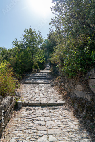 paved alley that goes up to the village Oppéde le Vieux village in Provence luberon France © OceanProd
