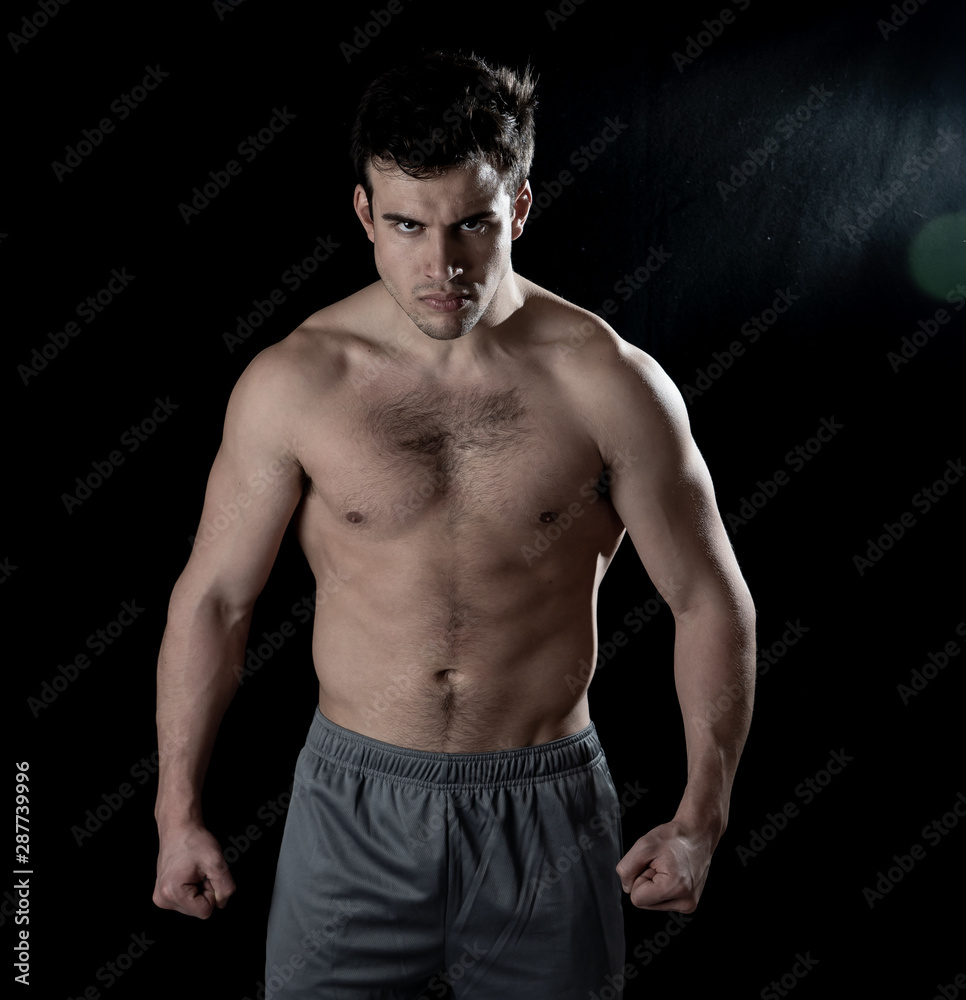 Young fitness muscly man showing his back,shoulders, triceps and biceps muscles after training Young fitness muscly man showing his back,shoulders, triceps and biceps muscles after training
