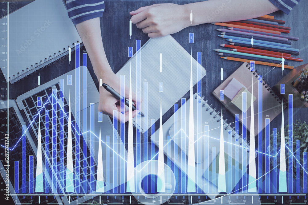 Fototapeta premium Financial forex graph drawn over hands taking notes background. Concept of research. Double exposure
