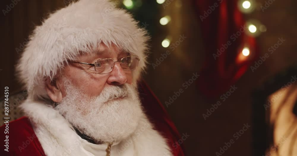 Santa clause sitting on his rocker and giving cute caucasian girl a christmas present - tradition, holidays and celebrations concept 4k footage Santa clause sitting on his rocker and giving cute caucasian girl a christmas present - tradition, holidays and celebrations concept 4k footage